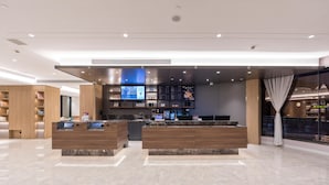 A modern hotel lobby with a reception desk, digital screens, and a marble floor. - Hanting Shanghai Lujiazui Oriental Pearl (Shanghai)