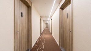 A hotel hallway with wooden doors, a carpeted floor, and a long corridor. - Hanting Shanghai Lujiazui Oriental Pearl (Shanghai)
