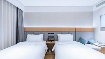 Ein modernes Hotelzimmer mit einem großen Bett, einem Nachttisch, einem Fernseher und einem Fenster mit Vorhängen.