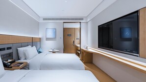 A hotel room with two beds, a TV, a bedside table, a small round table, and a door leading to the bathroom. - JI Hotel (Shanghai)