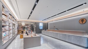 A modern interior with a reception desk, shelving units, and a clean, minimalist design. - JI Hotel (Shanghai)