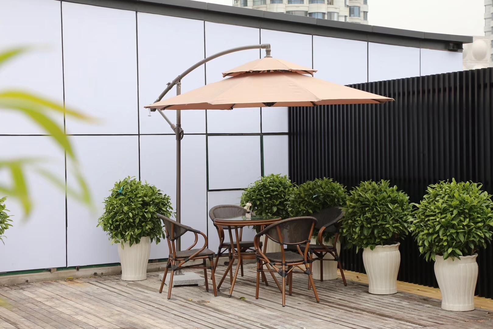 An outdoor patio with a table and chairs, surrounded by potted plants.