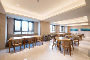 A spacious dining area with multiple tables and chairs, large windows, and a modern ceiling design. - Ji Hotel Harbin Songbei Sunac Paradis (Harbin)