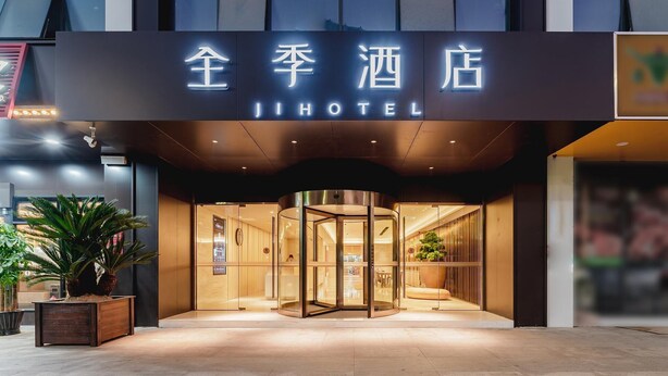 A hotel entrance with a modern design, featuring a glass door entrance and a sign with illuminated characters. - Ji Hotel Hangzhou South Railway Station (Hangzhou)