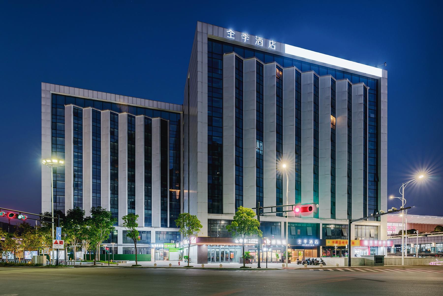 A modern hotel building with a prominent sign at the top.