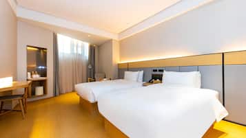 Een hotelkamer met twee bedden, een bureau en een stoel.