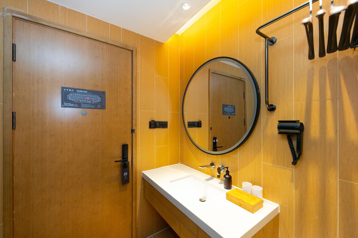 A modern bathroom with a wooden vanity, a sink, a mirror, and a towel rack.
