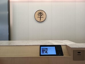A reception desk with a tablet displaying a welcome message. - Ji Hotel (Wuhan)