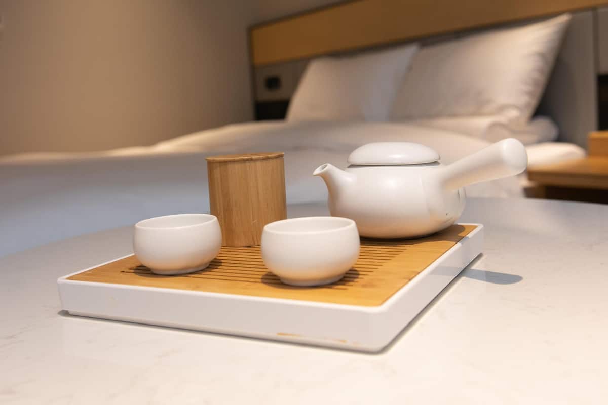 A neatly arranged tea set on a tray in a hotel room.