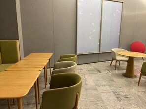 A modern meeting room with a long table, several chairs, a whiteboard, and a red ball on a table. - Ji Hotel (Wuhan)