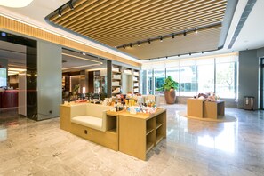 A spacious lobby with a reception desk, seating area, and large windows offering views of the outdoors. - Ji Hotel (Wuhan)