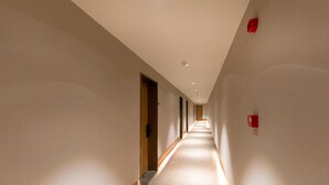 Un long couloir étroit, doté d’un tapis à motifs et de boiseries.