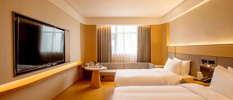 Habitación de hotel con dos camas, televisión, una mesita y ventana con cortinas.