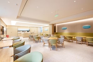 A modern restaurant with a central dining area, booths, and a bar. - Ji Hotel Pangdonglai Life Plaza Old Pedestrian St (Xinxiang)