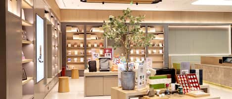 A modern bookstore interior with wooden shelves, a central display table, and a potted plant.
