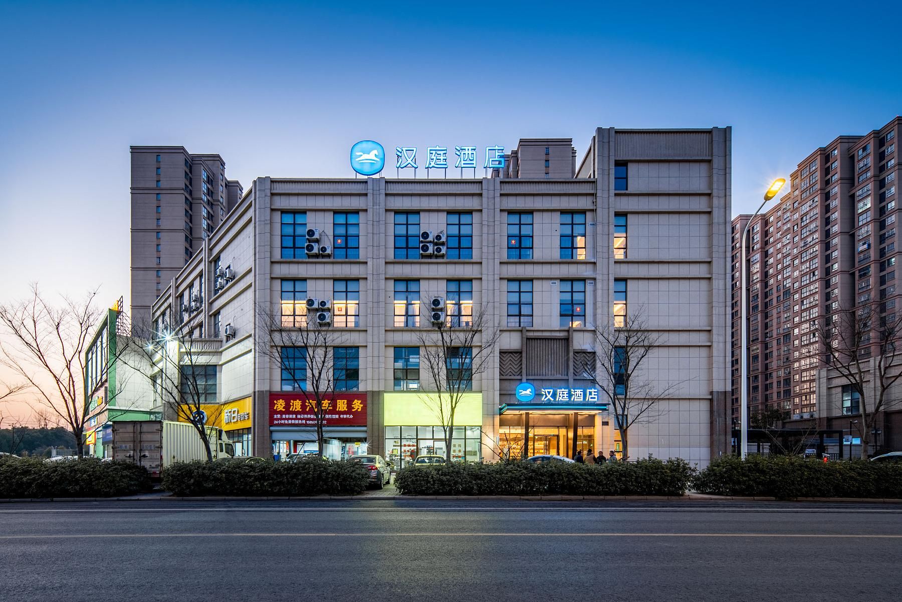 A multi-story hotel with a prominent sign, large windows, and a modern facade.
