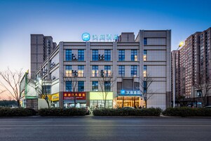 A multi-story hotel with a prominent sign, large windows, and a modern facade.