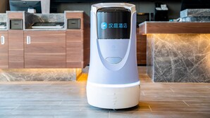 A modern, automated hotel reception desk with a digital display.