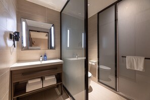 A modern bathroom with a glass shower enclosure, a wooden vanity, and a large mirror. - Hanting Hotel (Chuzhou)