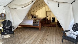 A tented accommodation with a single bed, a chair with a motivational quote, and a view of the outdoors. - Yellowstone Dreamin Camp (Pray)