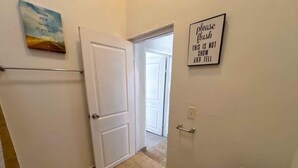 A bathroom with a toilet, a sink, and a shower. There is a door leading to another room. - Shoreline Condo 4 Desert Oasis Free Wifi Cool  AC (San Felipe)