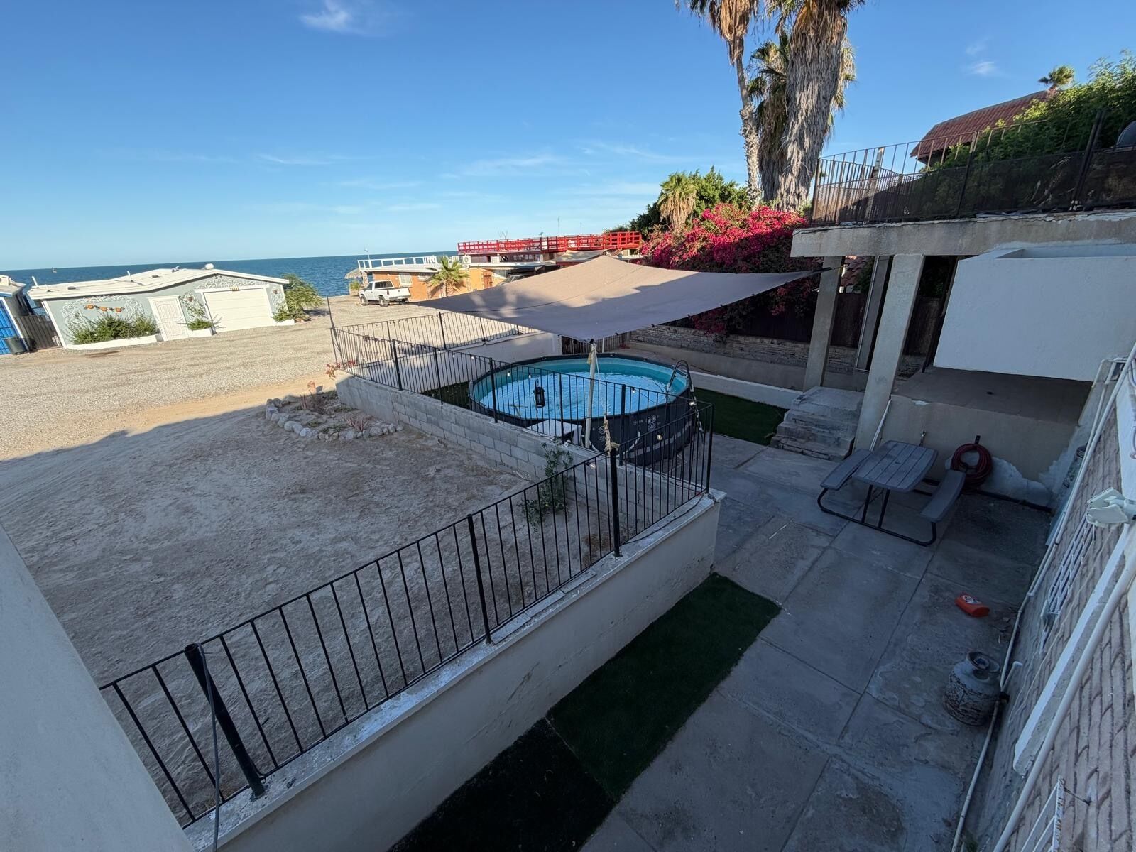 Une propriété résidentielle dotée d’une piscine, d’un patio couvert et offrant une vue sur la mer.