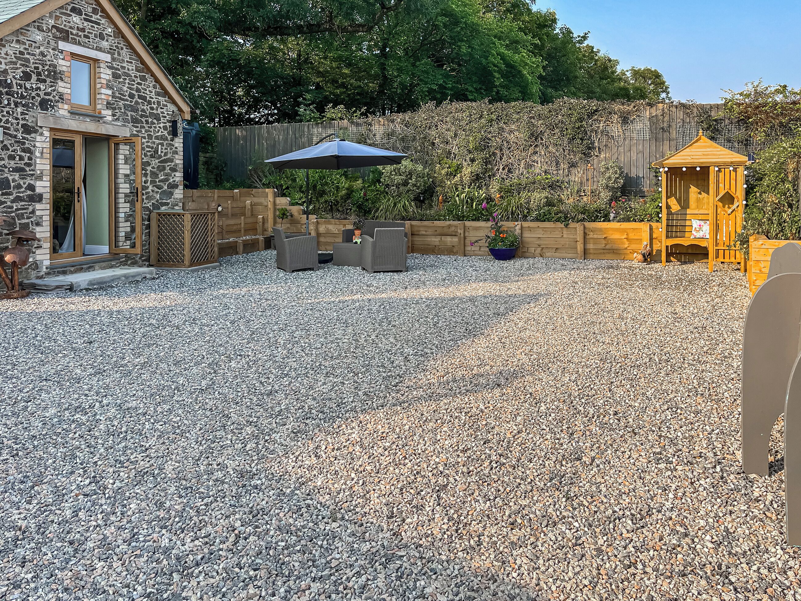 A stone building with a wooden deck, outdoor seating, and a gazebo.
