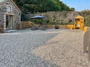A stone building with a wooden deck, outdoor seating, and a gazebo. - 1 bedroom accommodation in Holsworthy (Holsworthy)