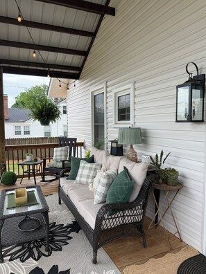 A covered porch with a sofa, chairs, and a table, featuring a hanging plant and a lantern. - Masters Rental - Augusta, Ga. 1/2 mile from Augusta National (Augusta)