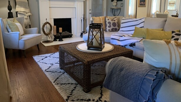 Una sala de estar con chimenea, un sofá, una mesa de centro y una cesta de mimbre.