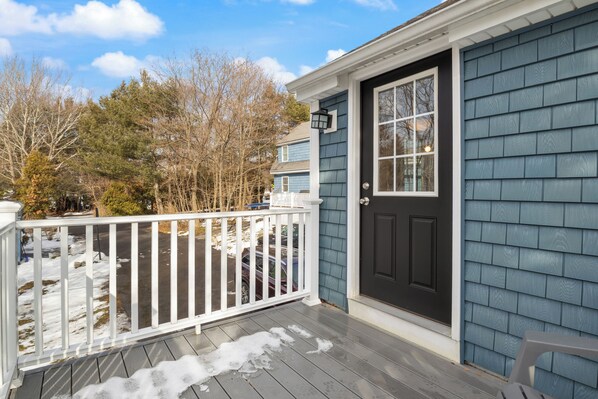 A house with a dark blue exterior, a white front door, and a white porch railing. - Coastal Cottage in the heart of Kennebunk, ME (Kennebunk)