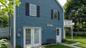 A two-story house with a blue exterior, white trim, and a front porch. - Coastal Cottage in the heart of Kennebunk, ME (Kennebunk)