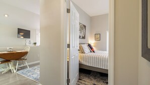 A bedroom with a bed, a desk with a chair, and a dining table. - Coastal Cottage in the heart of Kennebunk, ME (Kennebunk)
