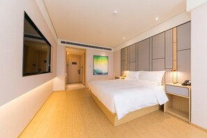 Una camera d'albergo con un letto grande, un comodino e un quadro appeso al muro.