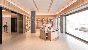 A modern interior with a central display area, bookshelves, and a large window providing a view of the outside. - Ji Hotel (Zhengzhou)