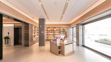 A modern interior with a central display area, bookshelves, and a large window providing a view of the outside.