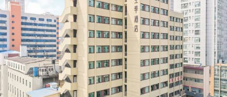 Un hôtel à plusieurs étages au design moderne, doté d’une entrée imposante et d’une terrasse sur le toit.
