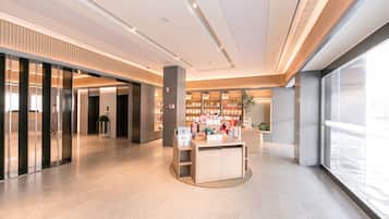 A modern interior with a reception desk, bookshelves, and a large window.