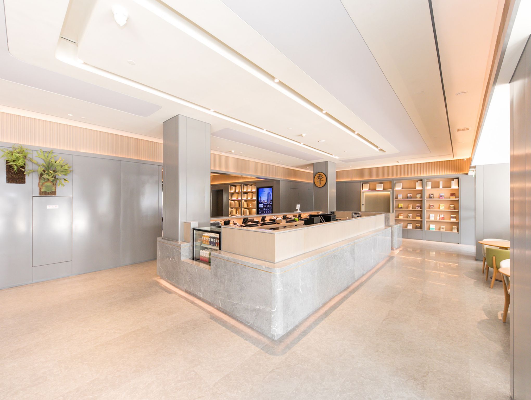 A modern reception area with a marble counter, a digital display, and a bookshelf.
