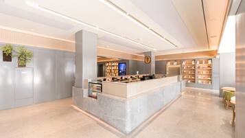 A modern reception area with a marble counter, a digital display, and a bookshelf.