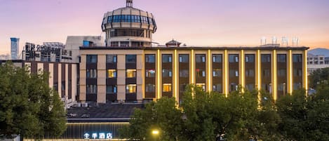 A hotel with a prominent dome structure, multiple floors, and a well-lit entrance.