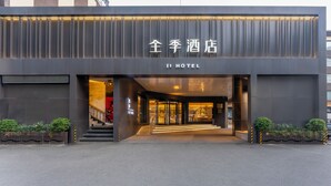 A modern hotel entrance with a sign reading 'JI HOTEL' and a visible staircase leading inside. - Ji Hotel (Wenzhou)