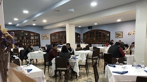 A restaurant with multiple tables, chairs, and a stone-tiled floor. - Hotel El Molino de Pancorbo (Pancorbo)