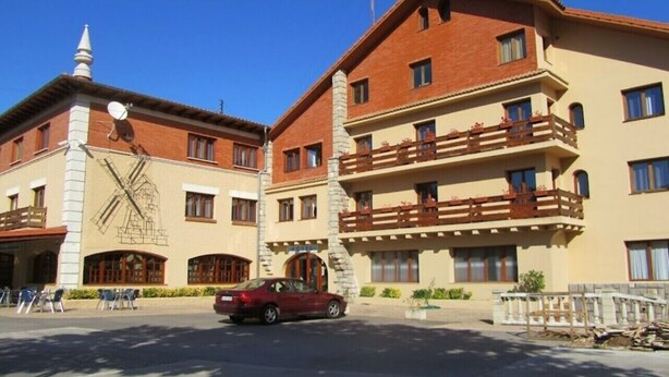 A multi-story hotel with a traditional architectural style, featuring balconies and a prominent windmill sculpture on the facade. - Hotel El Molino de Pancorbo (Pancorbo)