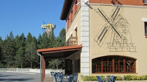 A hotel with a covered outdoor seating area and a large architectural drawing on the building facade. - Hotel El Molino de Pancorbo (Pancorbo)
