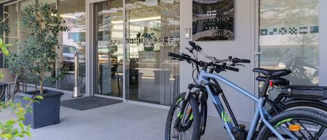 A modern building with glass doors, a mounted bicycle, and a sign reading "Flag Design Hotel".