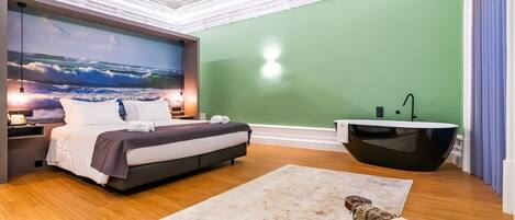 A modern bedroom with a bed, a large wall mural, a bathtub, and a wooden floor.