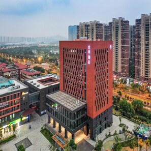 A modern building with a red facade and a sign reading "Full Year Hotel". - Ji Hotel (Nanjing)