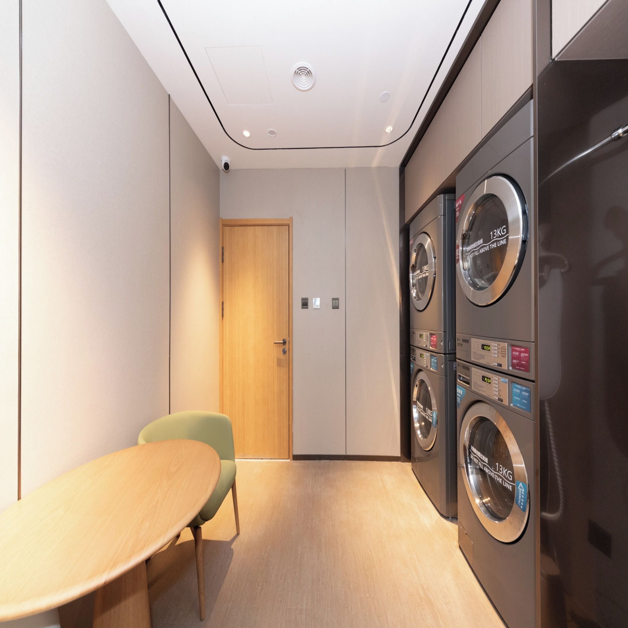 Quarto moderno com porta de madeira, uma mesa e um espaço de estar.