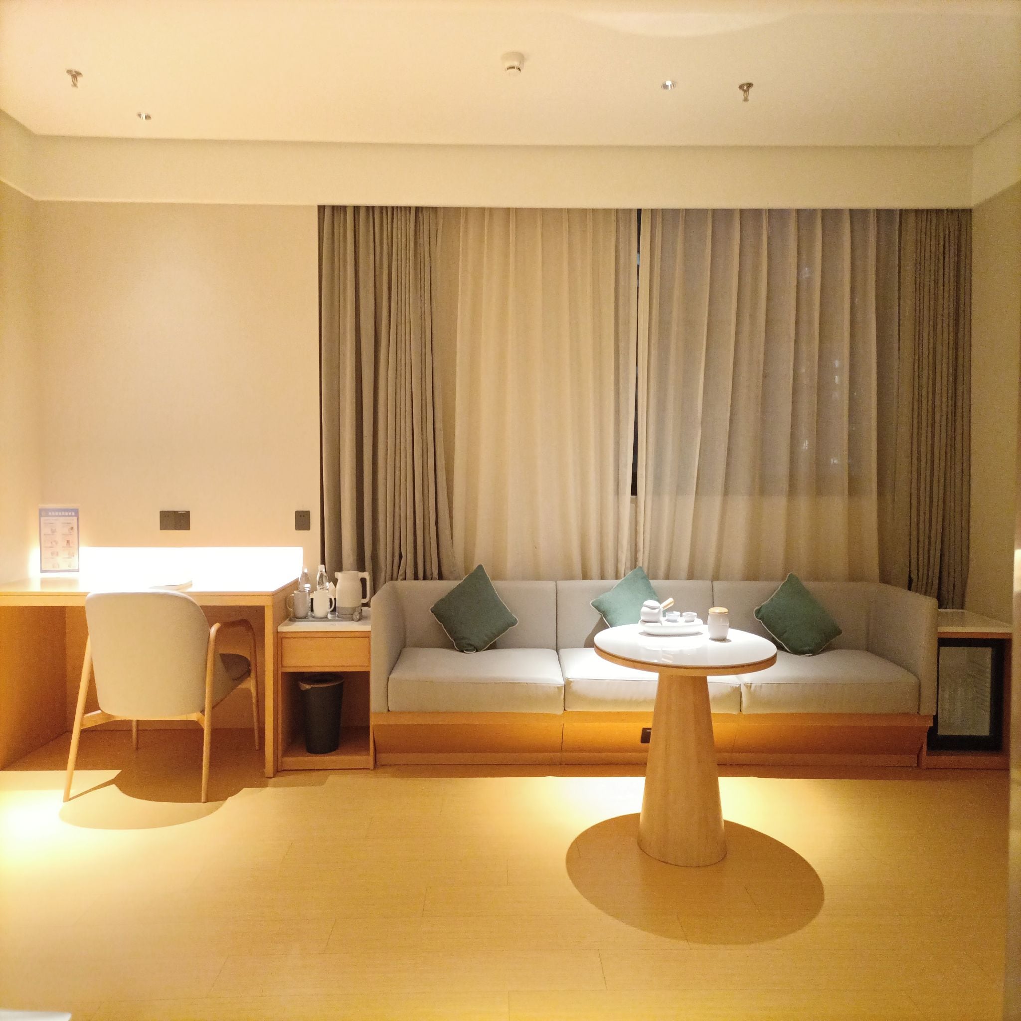 Uma sala de estar moderna com um sofá, uma mesa de centro e uma escrivaninha com uma cadeira.